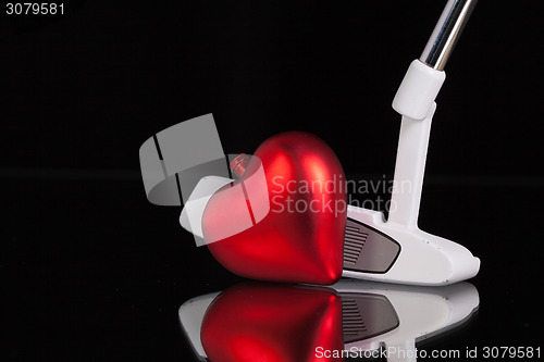 Image of Golf putter and love symbol on the black glass desk