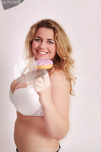 Image of Woman with big tits has a colorful muffin on the finger