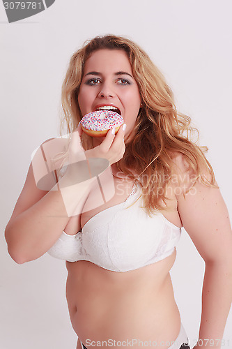 Image of Woman with big tits eats a colorful muffin.