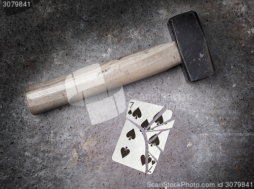 Image of Hammer with a broken card, seven of spades