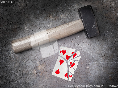 Image of Hammer with a broken card, seven of hearts
