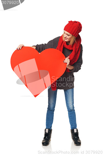 Image of Full length girl holding up a red cardboard heart