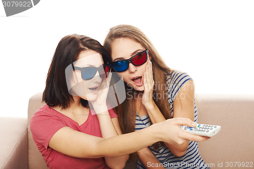 Image of Three surprised women with TV remote control