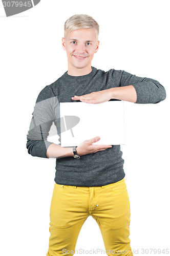 Image of Smiling young casual man holding white sign 
