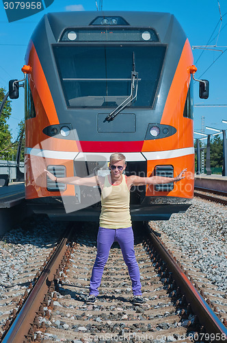 Image of Young trendy guy in front of train