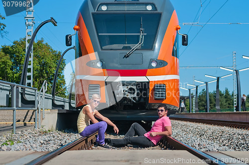 Image of Young trendy guys in front of train