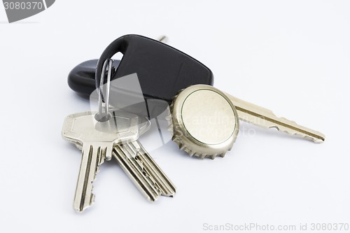 Image of car key and bottle cap in close up