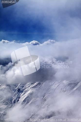 Image of View on off-piste slope at mist and sunlight clouds