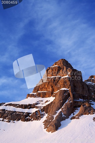 Image of Snowy sunlight rocks at sunrise