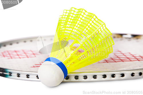 Image of One shuttlecock lying near the badminton racket