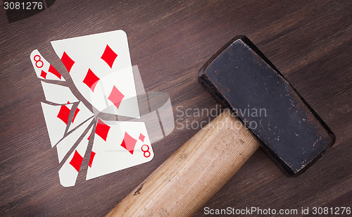 Image of Hammer with a broken card, eight of diamonds