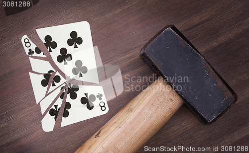 Image of Hammer with a broken card, eight of clubs