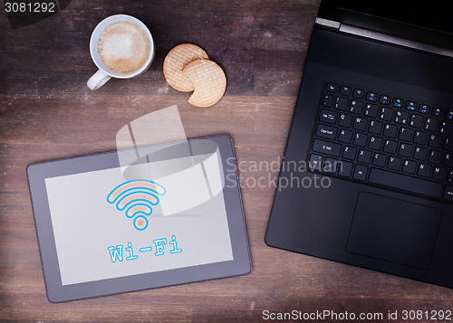 Image of Tablet with Wi-Fi connection on a wooden desk