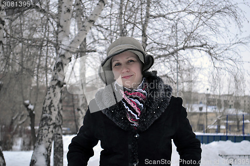 Image of The woman in a hat and a sheepskin coat costs in park in the win