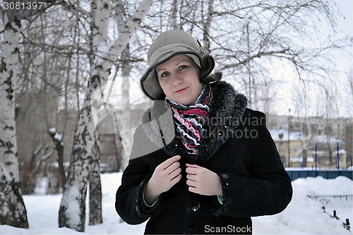 Image of The woman in a hat and a sheepskin coat costs in park in the win