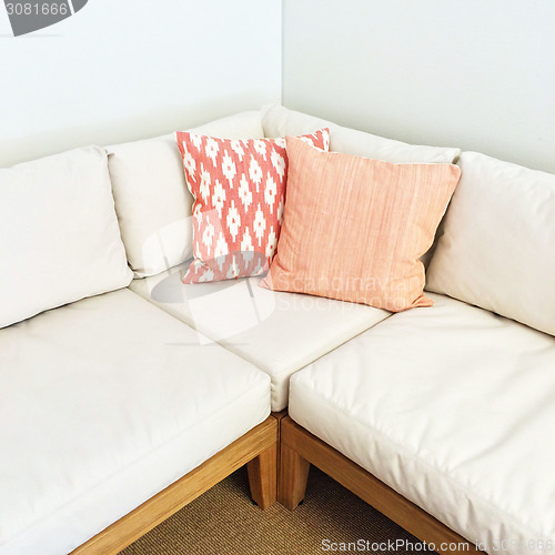 Image of White corner sofa with pink cushions