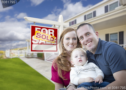 Image of Young Military Family in Front of Sold Sign and House