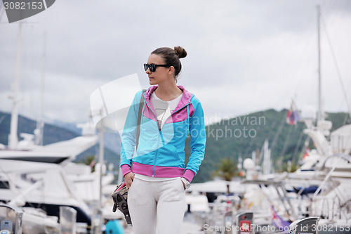 Image of relaxed young woman walking in marina