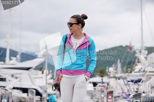 Image of relaxed young woman walking in marina