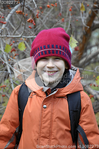 Image of portrait of the joyful teenage boy in the autumn wood.