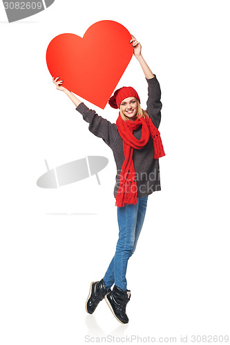 Image of Full length girl holding up a red cardboard heart