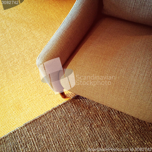 Image of Textile armchair and knitted carpet in warm colors