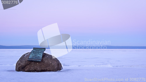 Image of Memorial plaque on boulder on lake shore in winter