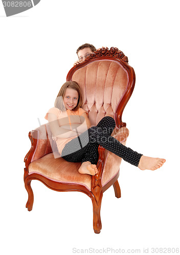 Image of Young girl in pink armchair.