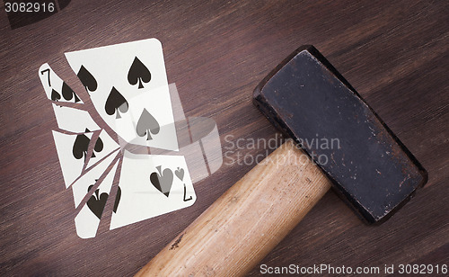 Image of Hammer with a broken card, seven of spades