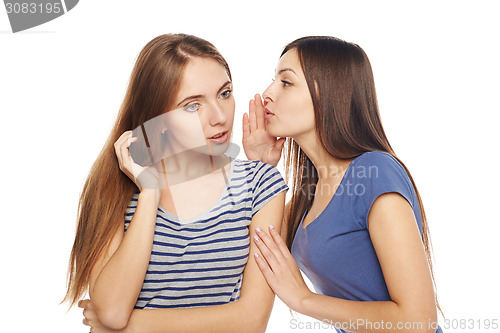 Image of Two smiling girls friends whispering