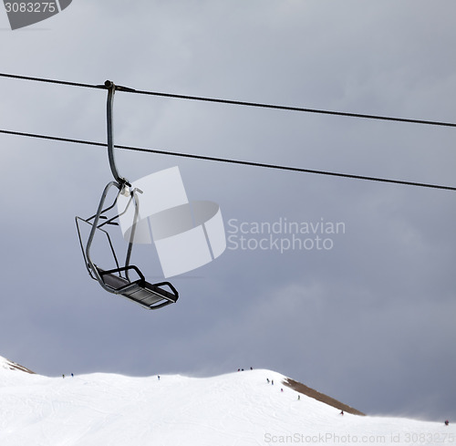 Image of Chair lift and off-piste slope at gray windy day