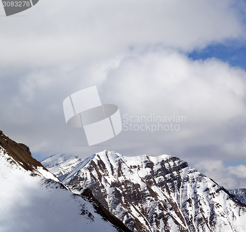 Image of Winter snowy mountains and sky with clouds