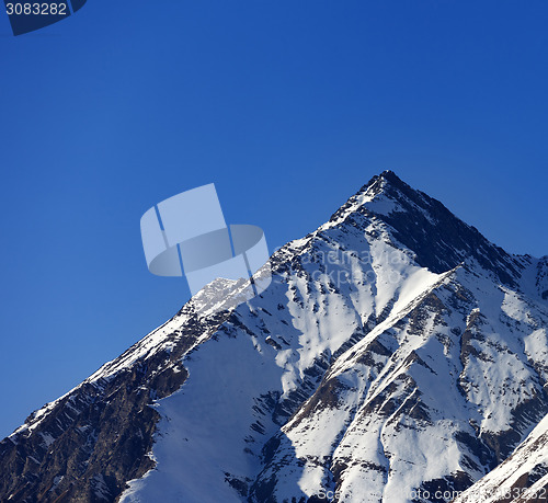 Image of Snowy rocks in sun evening