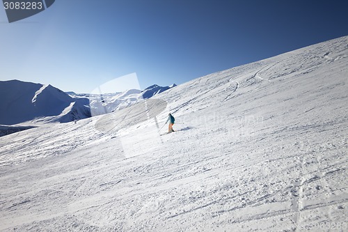 Image of Skier on slope in sun day