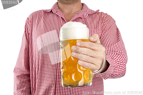 Image of Man in traditional Bavarian shirt holds mug of beer 