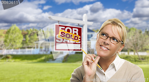 Image of Young Woman in Front of Sold Sign and House