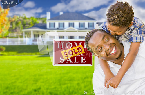 Image of Father and Son In Front of Sold Sign and House
