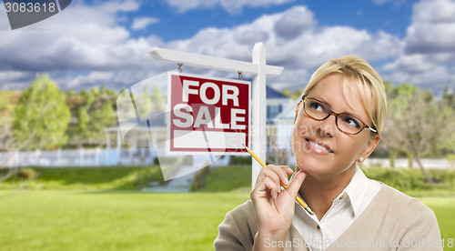 Image of Young Woman in Front of For Sale Sign and House