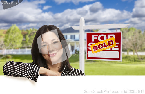 Image of Hispanic Woman in Front of Sold For Sale Sign, House