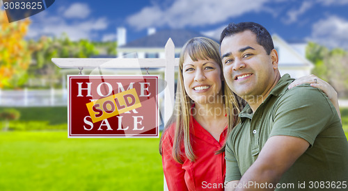 Image of Couple in Front of Sold Real Estate Sign and House