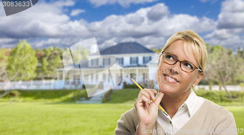 Image of Young Woman With Pencil in Front of House