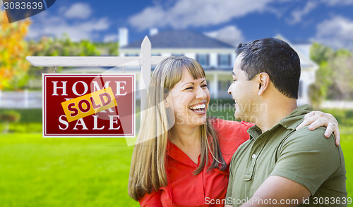 Image of Couple in Front of Sold Real Estate Sign and House
