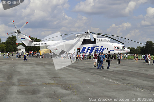 Image of People consider the helicopter of the UTair company at an air sh