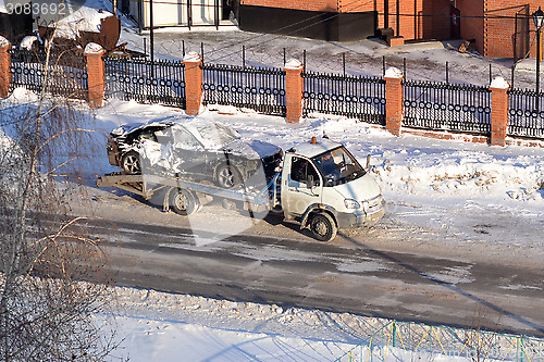 Image of transportation of the broken car in the winter.