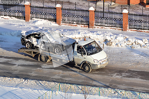 Image of transportation of the broken car in the winter.