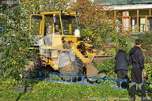 Image of Cleaning of the cut branches of trees by means of a tractor.