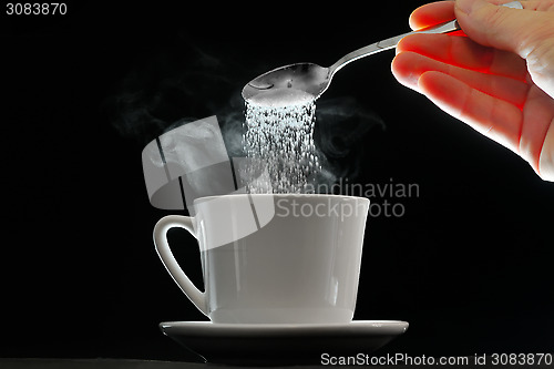 Image of Coffee cup and pouring sugar spoon