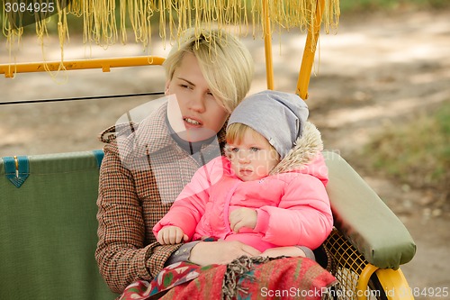 Image of Beautiful Mother And Baby outdoors. Nature. Beauty Mum and her Child playing in Park together. Outdoor Portrait of happy family. Joy.