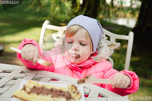 Image of Child eating waffles with chocolate 