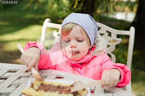 Image of Child eating waffles with chocolate 